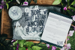 Our understated yet impactful heathered grey Christian tee, featuring the powerful message, "The hope we have as an anchor of the soul."
