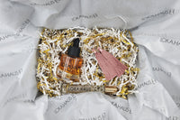 LOKA.HAUS beauty: 'Duality Oil' in amber, center 'Intensity Parfum Roller', & luxe tassel earrings on right. Elegance in a subscription box.