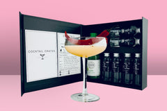 A Cocktail subscription box displaying a margarita picante cocktail in front of a gift box from Cocktail Crates