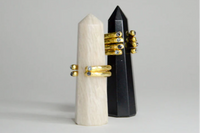 Elegant gold-plated ring by LOKA.HAUS, displayed on a sleek black stand. Sustainable fashion, ethical luxury for social impact.