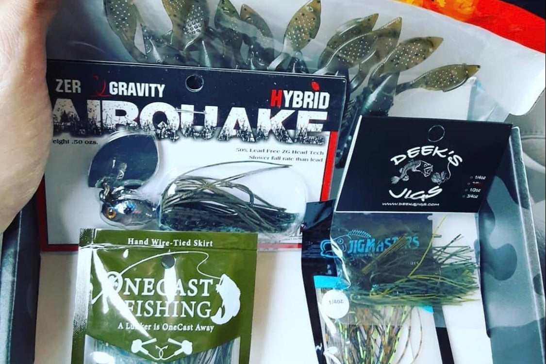 An open Dark Horse Tackle subscription box filled with several types of fishing lures.
