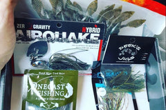 An open Dark Horse Tackle subscription box filled with several types of fishing lures.