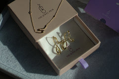 A thejewelpick gift box containing a necklace and earrings.