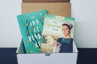 A book titled "Once Upon a Dickens Christmas" next to a Truly Yours Fiction Box subscription card featuring Christian themes