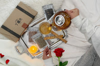 A hand pours tea from a kettle into a cup beside a Tea Runners subscription box and loose leaf tea packages