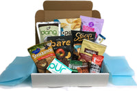 Box filled with snacks such as snackimals, boom chicka pop, back to nature, stacys pita chips, dang, pur gum, health warrier chia bar