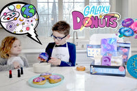 Two children engaged in the I'm The Chef Too! cooking kit, creating galaxy donuts with colorful icing and sprinkles