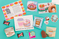 Donut patch and flavored jelly beans, pocket latte chocolate, candle, donut and coffee greeting card, make up sponge on blue background.
