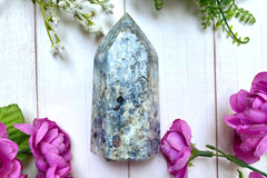 A photo of a blue and white crystal point with garnet inclusions as an example of a crystal of the month offered by Soul Gifts Crystals,