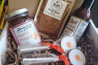 Fiery mini gift box filled with hot sauce, sweet and spicy treats, fiery dip and condiments and other spicy goods.