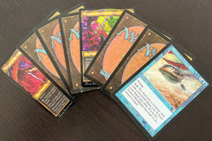 Assortment of curated rare cards and Magic: The Gathering cards from throughout Magic history against a dark background