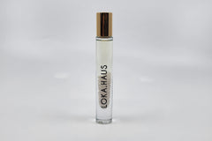 Tall bottle with gold cap: LOKA.HAUS's 'Intensity Parfum Roller'. Luxurious scent, crystal clarity. Elegance rolls on.
