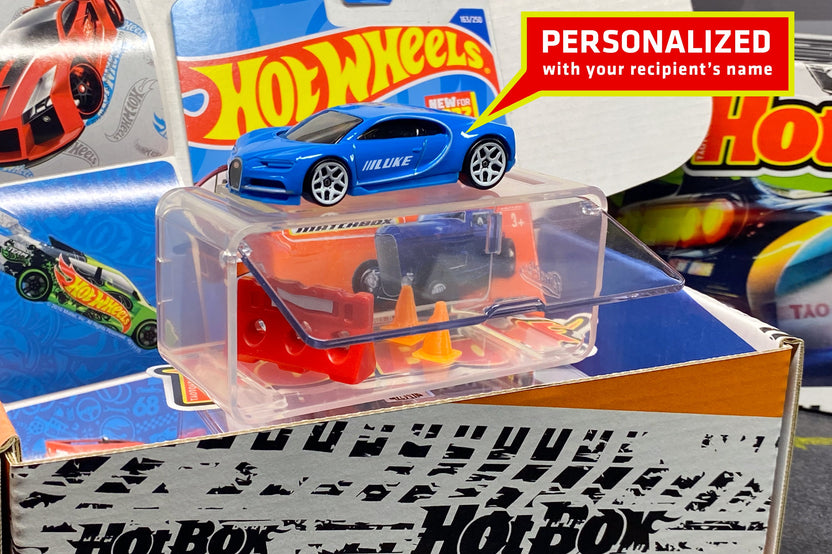The Hot Wheels monthly subscription box containing a personalized car with name, display case, additional new cars, and accessories.