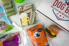 Variety of dog treats (bones and dehydrated fish/meat). Also includes teething toy, hamburger toy, and potty accessories. 