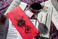 Scarlet Envelope Secret Society subscription box with red envelope, mystery clues, and a glass of wine for a date night experience