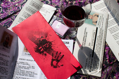 Scarlet Envelope Secret Society subscription box with red envelope, mystery clues, and a glass of wine for a date night experience