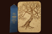 Wood panel with a detailed woodburned tree design alongside a blue first place ribbon from a state fair, part of the Craftsman Crate subscription box