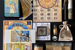Items from a The Witches Moon subscription box, including a large crystal on a satin pouch and a card showing zodiac signs.