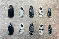 Set: Zebra'd. Black and white alternating zebra inspired set. Zebra french tip on thumbs. Black star gems on index/ring. Zebra hearts on mid