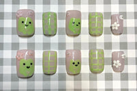Set: Hop into Spring. Pink and green frog nails. Pink and white flower charms. green gingham on index and ring. frog on thumb and middle