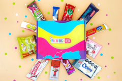 Pachanga Box with yellow background with some Latin American snacks int he shape of a star or sun with dots for esthetics. 
