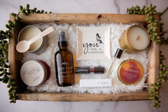 An image showcasing a selection of self-care items: a mood-enhancing candle, a vibrant lipstick, and an elegant trinket dish.
