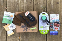 Wild Woman Box subscription boxes stacked on a mountain ledge with a scenic view in the background