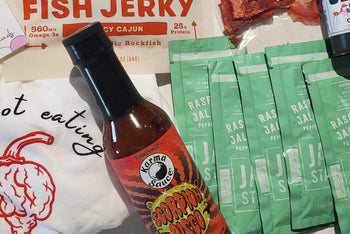 Bottle of Karma Sauces hot sauce, raspberry jalapeno jam packages for easy portability, fish jerky are just some of the items in our boxes. 