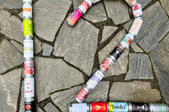 12 cans of cider, arranged in the shape of the number 12, against a mosaic stone background. 