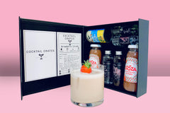 A Cocktail subscription box displaying a negroni cocktail in front of a gift box from Cocktail Crates