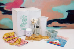 The 2022 Summer Box: pitcher, wood flower diffuser, whipped sugar scrub, olive wood breakfast board, ceramic berry basket, reusable towels.