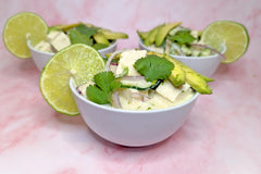 Three small bowls containing coconut tofu ceviche. They are each garnished with sliced avocado, cilantro leaves, and a lime wheel.