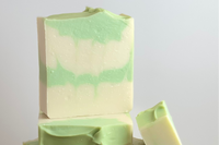 Green and white swirled bars of soap stacked on top of each other with a bar leaning on the stack. This is the Eucalyptus Mint soap. 