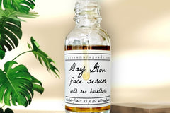 The Day Glow Serum by Greenmade goods. A bottle with golden serum dripping down over the label. Monstera plant in the background.