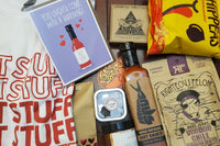 box filled with spicy food items to celebrate Valentine's Day and includes hot sauce, t-shirt, spicy sweets and condiments. 