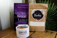 A red mug filled with three packets of Moonstruck milk chocolate, featured in the Peace & Pages monthly subscription box