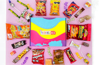 Pachanga Box surrounded by various Mexican and Colombian snacks on a pink background in a subscription box layout