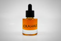 Amber bottle of LOKA.HAUS's 'Duality Facial Oil'. A radiant glow captured in elegant packaging. Pure beauty in every drop.