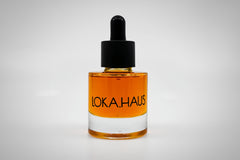 Amber bottle of LOKA.HAUS's 'Duality Facial Oil'. A radiant glow captured in elegant packaging. Pure beauty in every drop.