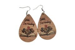 Shhh...I'm Reading wooden teardrop earrings with an open book below, and flowers growing out of the open book