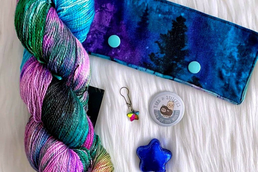 A sample of the Hand Dyed Yarn, stitch marker and extra items that will be offered in each quarterly box.