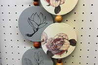 Wall hangings that are hand painted and beaded by one of our artisans. These also work great in tiered trays. 