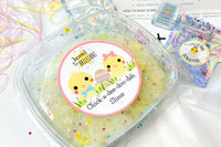 Prepared chickadeedodah slime in its resealable container, along with an empty pouch that the glitter was in and the leftover activator.