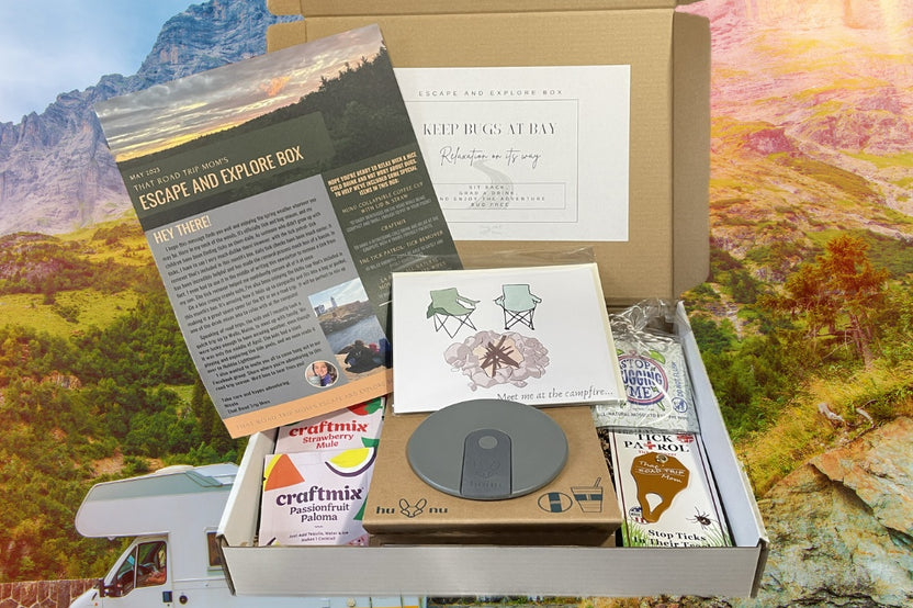 May Escape and Explore box curated with a collapsible cup, drink mixes, tick remover and bug repellant wipes, plus a bonus greeting card. 