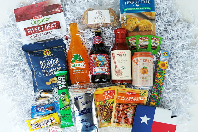 Pictured is organic beef jerky, Bucc-ees nuggets, Texas BBQ sauce, Mexican seasonings, pecan log, cornbread mix, and other Texas foods/drink