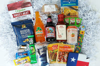 Pictured is organic beef jerky, Bucc-ees nuggets, Texas BBQ sauce, Mexican seasonings, pecan log, cornbread mix, and other Texas foods/drink