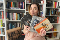 Owl Post Books YA Imagination Box. Three new hardcover books delivered monthly. Picture shows woman smiling with her new books in library. 