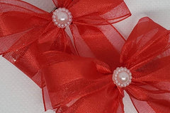 Red satin organza blend ribbon coupled with a pearl embellishment. A perfect accessory for Valentine's Day!