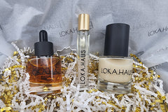 LOKA.HAUS: 'Duality Oil' in amber, center 'Intensity Parfum Roller' & right, 'Radiant Serum'. Elegance & quality shine in every drop.