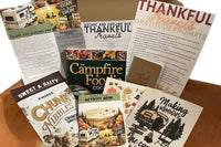 Thankful Travel themed box, Gratitude prompts, the campfire foodie cookbook, two Swedish dish clothes, chink nibble snack mix, activity book